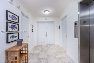 609 Ocean Drive, Unit 8G Key Biscayne, FL 33149 - Photo 10 of 44 a view of a hallway with paintings on the wall