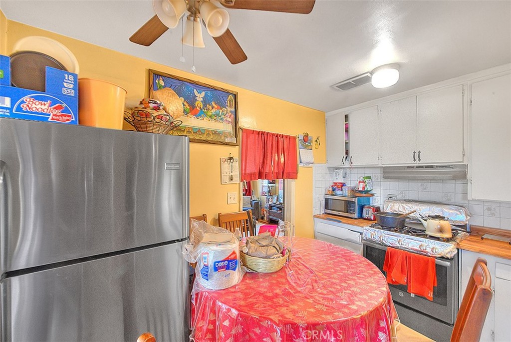8651 Encinitas Avenue Fontana, CA 92335 - Photo 13 of 35 a kitchen with stainless steel appliances granite countertop a refrigerator sink and white cabinets