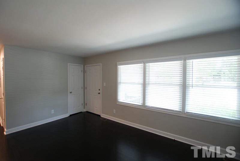 504 Cooper Road Raleigh, NC 27610 - Photo 2 of 21 a view of an empty room with wooden floor and a window