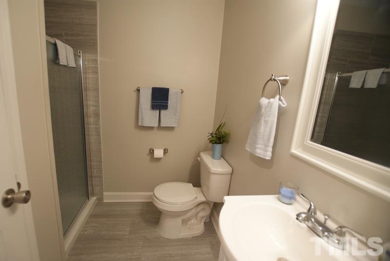 504 Cooper Road Raleigh, NC 27610 - Photo 14 of 21 a white toilet sitting next to a bathroom sink