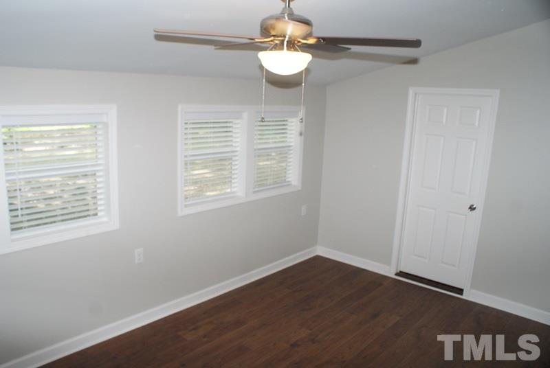 504 Cooper Road Raleigh, NC 27610 - Photo 16 of 21 a view of an empty room with wooden floor and a window