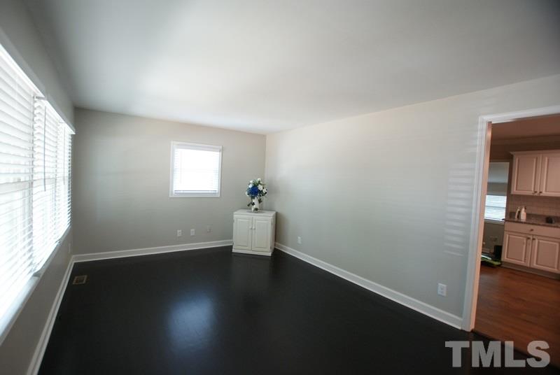 504 Cooper Road Raleigh, NC 27610 - Photo 3 of 21 an empty room with wooden floor and windows