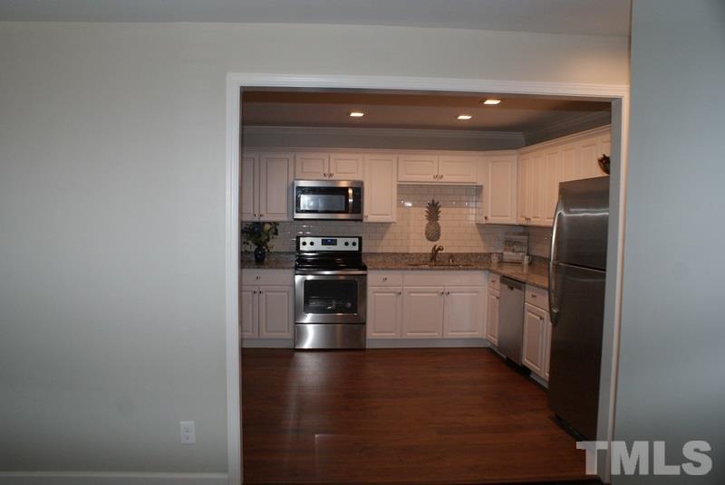 504 Cooper Road Raleigh, NC 27610 - Photo 4 of 21 a kitchen with a refrigerator and a stove top oven