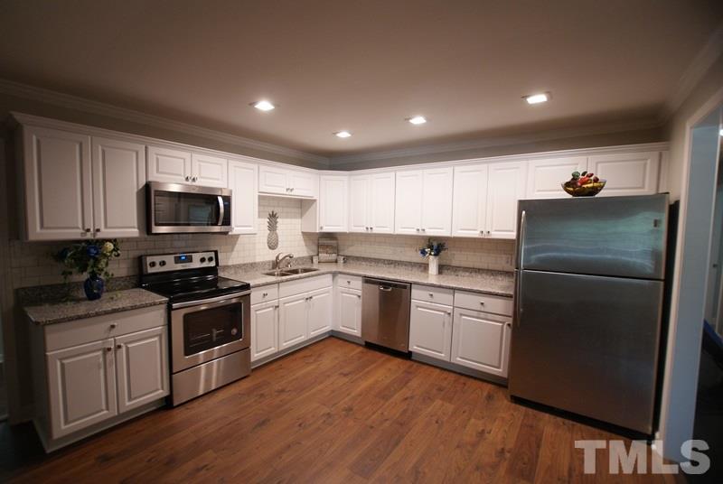 504 Cooper Road Raleigh, NC 27610 - Photo 5 of 21 a kitchen with a sink a microwave a refrigerator and cabinets
