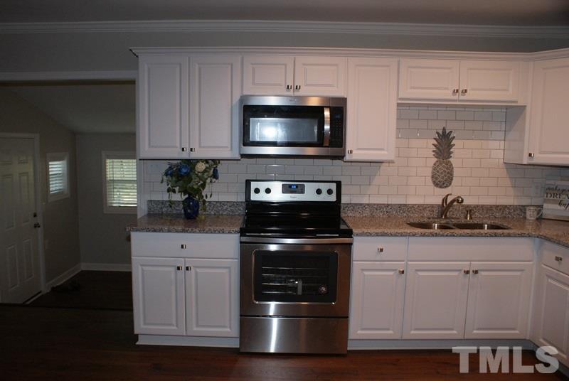 504 Cooper Road Raleigh, NC 27610 - Photo 6 of 21 a kitchen with granite countertop a stove and a sink