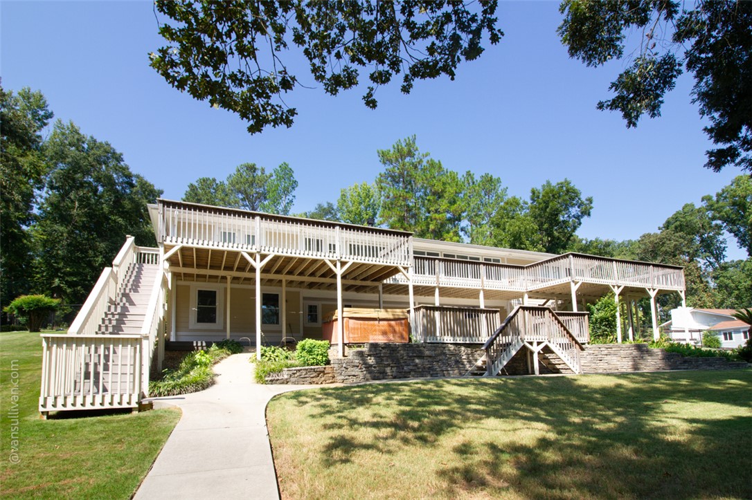 4518 Cove Trail Anderson, SC 29621 - Photo 8 of 49 An expansive multi-level wooden deck overlooks a grassy lawn framed by mature trees.