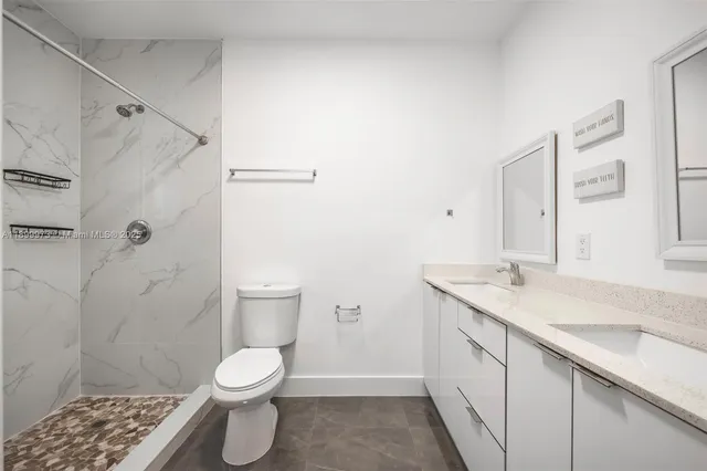 a bathroom with a granite countertop sink toilet and shower