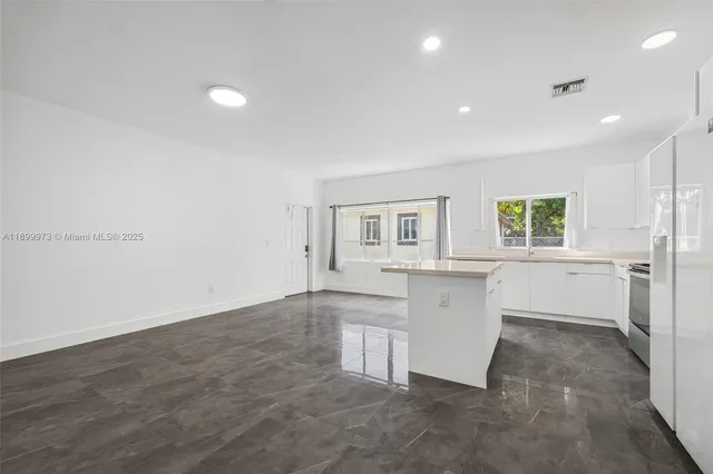 a view of a kitchen with white cabinets and wooden floor