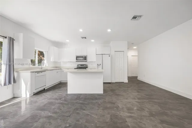a kitchen with white cabinets and white appliances