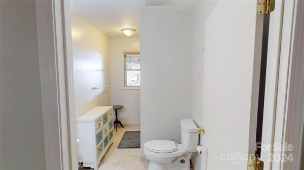 a bathroom with a granite countertop toilet and a sink