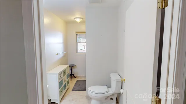 a bathroom with a granite countertop toilet and a sink