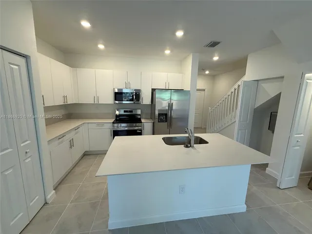 a kitchen with stainless steel appliances a refrigerator sink and cabinets