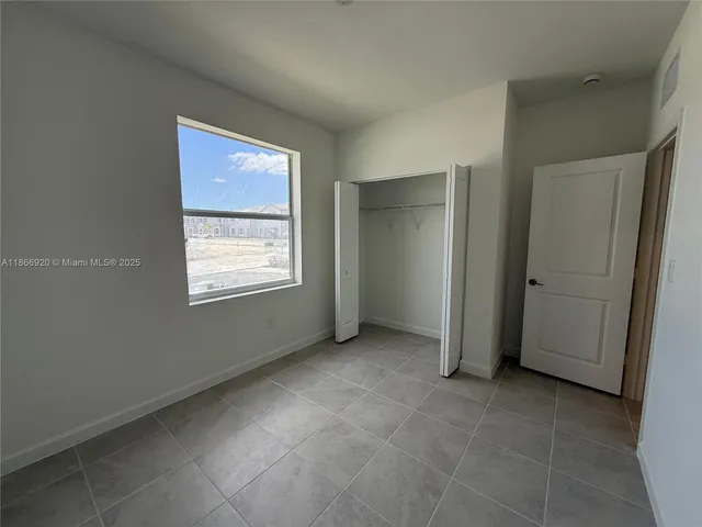 an empty room with windows and closet