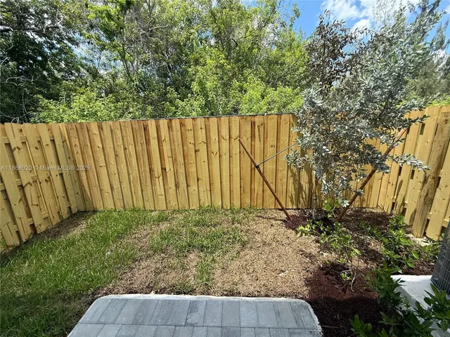 a view of garden with wooden fence