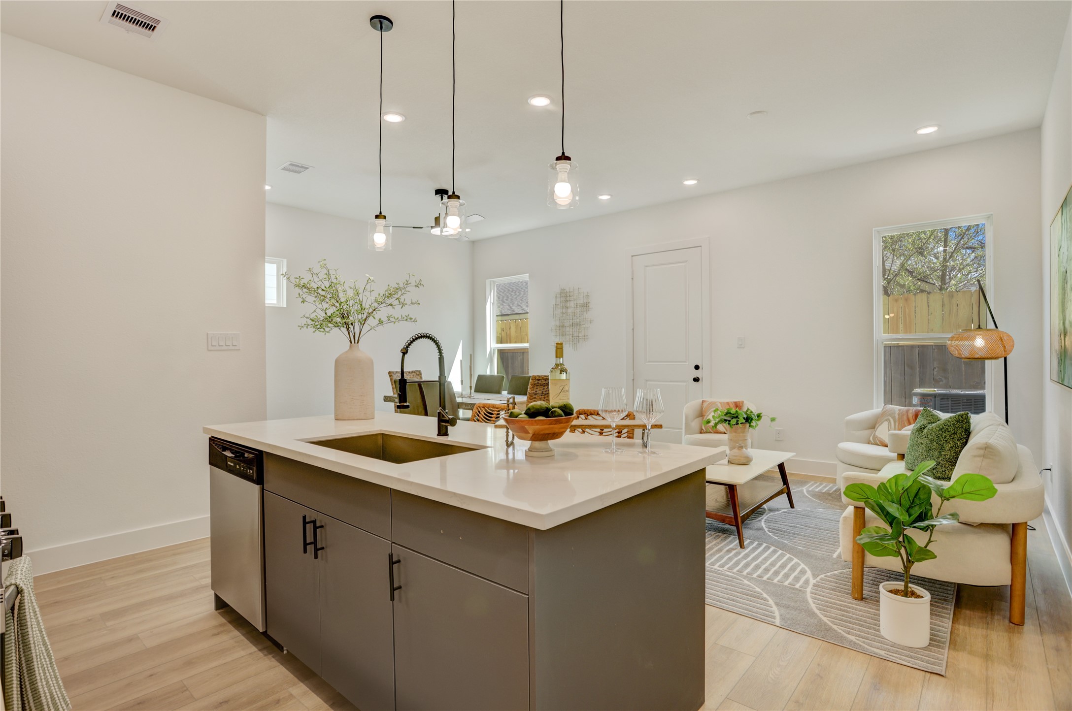 9604 Burden Street Houston, TX 77093 - Photo 14 of 28 The kitchen island has a stainless steel undermount Kohler sink with retractable faucet and drip accessories, and custom pendant lights.