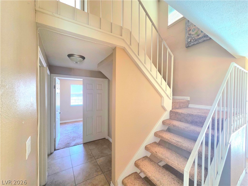 3648 Bronco Road Las Vegas, NV 89103 - Photo 20 of 24 A well-lit entry hall with carpeted stairs leading to the upper level.