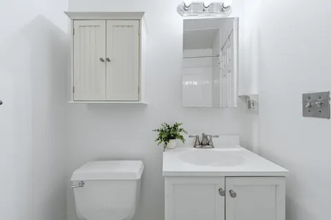 a bathroom with a sink a toilet and a mirror