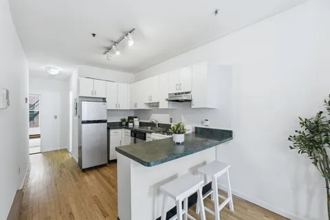 a kitchen with kitchen island a counter top space a sink stainless steel appliances and cabinets