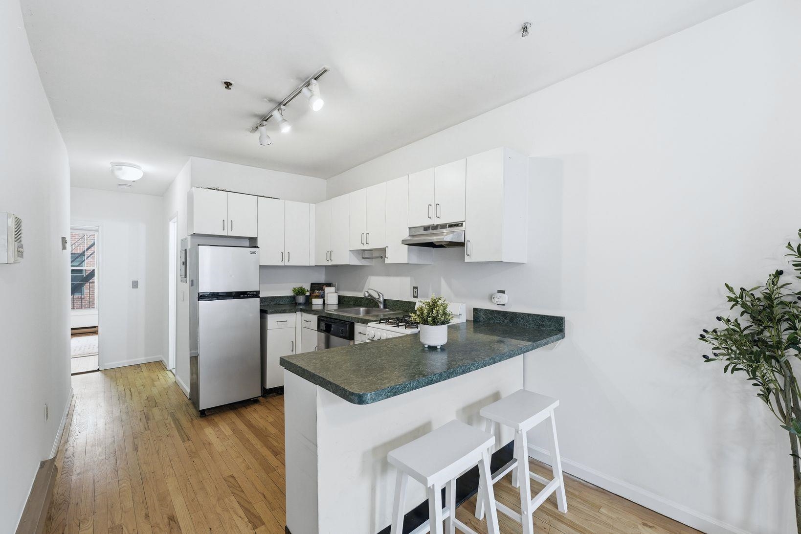 509 Monroe Street, Unit 3L Hoboken, NJ 07030 - Photo 6 of 18 a kitchen with kitchen island a counter top space a sink stainless steel appliances and cabinets