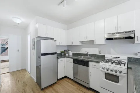 a kitchen with a stove a refrigerator and a sink