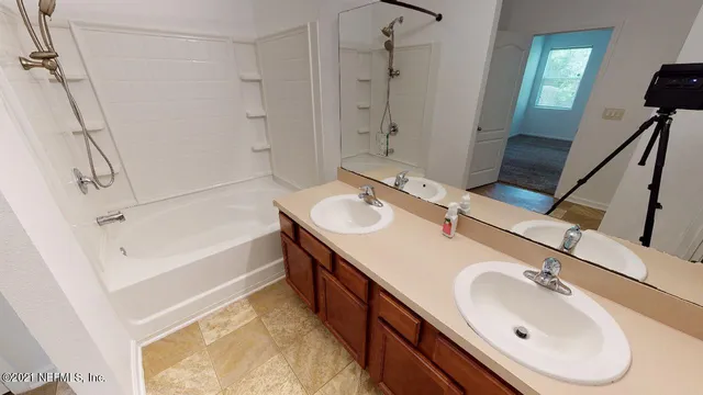 a bathroom with a tub sink and mirror