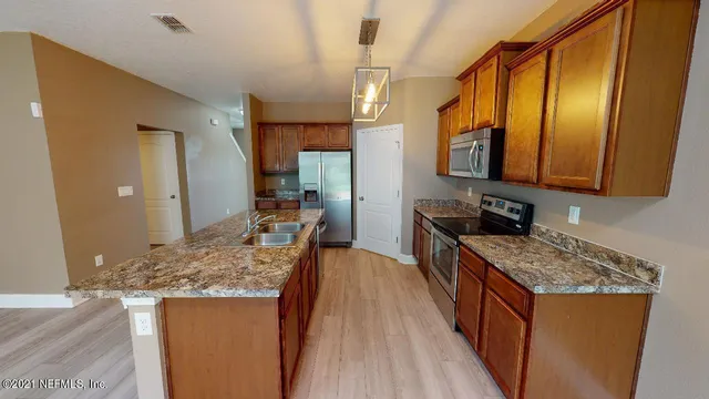 a kitchen with stainless steel appliances granite countertop wooden cabinets and sink