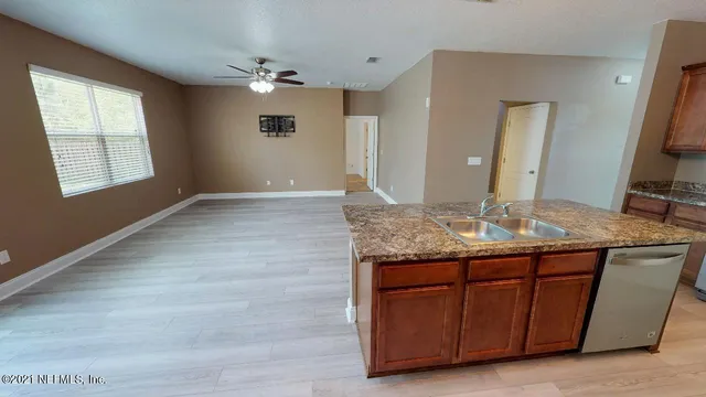 a view of kitchen with granite countertop cabinets and sink