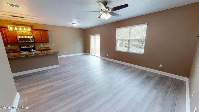 a view of a kitchen with wooden floor and a ceiling fan