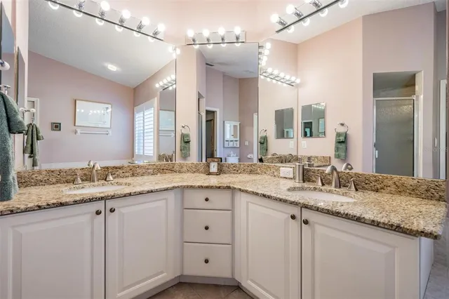 a bathroom with a granite countertop sink double and mirror