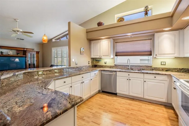 a large kitchen with granite countertop a sink and a stove top oven