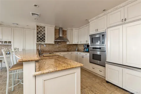 a kitchen with white cabinets and sink