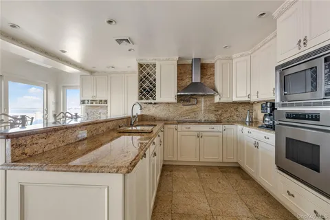 a kitchen with white cabinets and sink