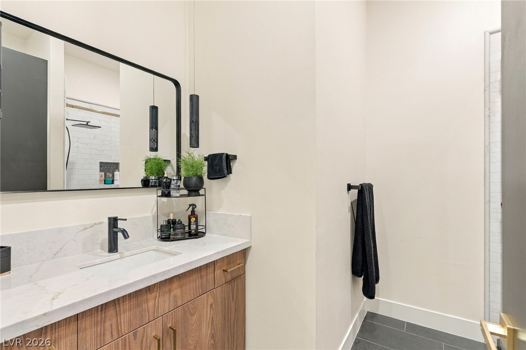 324 Wanda Road Henderson, NV 89002 - Photo 51 of 96 Clean lines and a stone-topped vanity define this contemporary restroom space.
