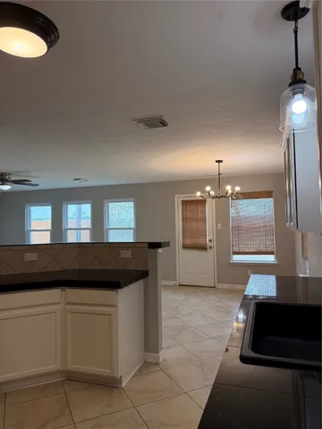 a living room with stainless steel appliances kitchen island granite countertop a black and white cabinets
