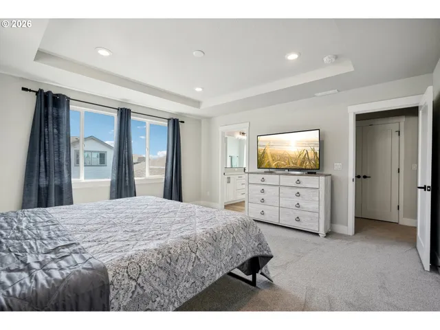 a living room with a bed and a flat screen tv