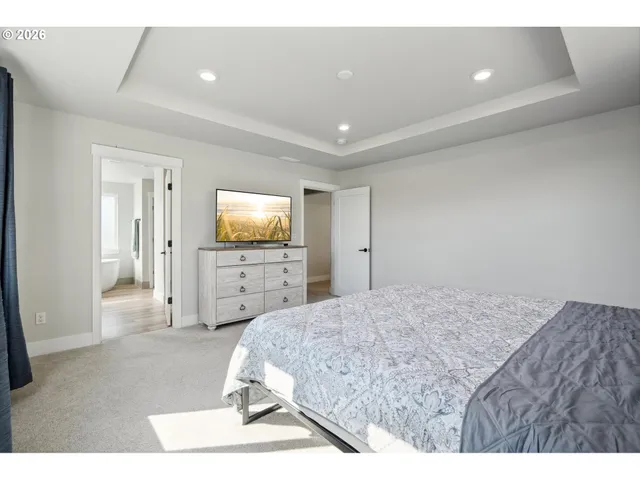 a spacious bedroom with a bed and a painting