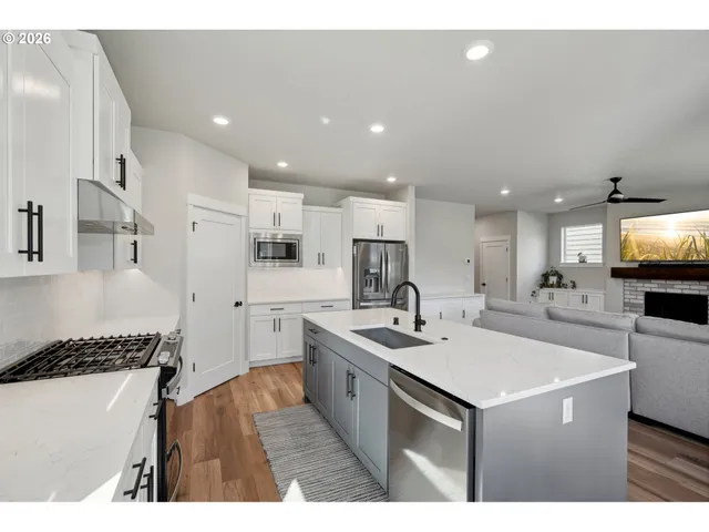 a kitchen with stainless steel appliances a sink a stove a refrigerator and cabinets