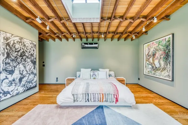 a bedroom with a bed and a painting on the wall