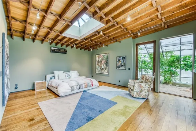 a bedroom with a bed with wooden floor