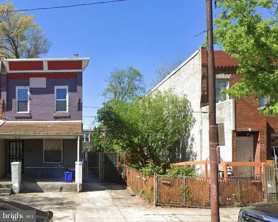 a front view of a house with a tree