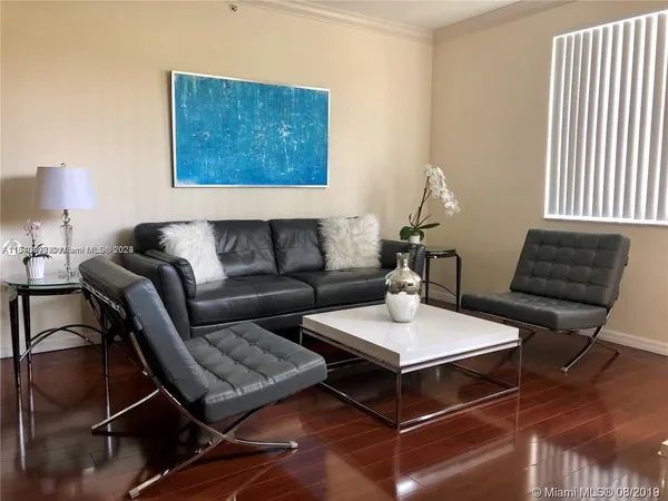a living room with furniture a rug and a lamp