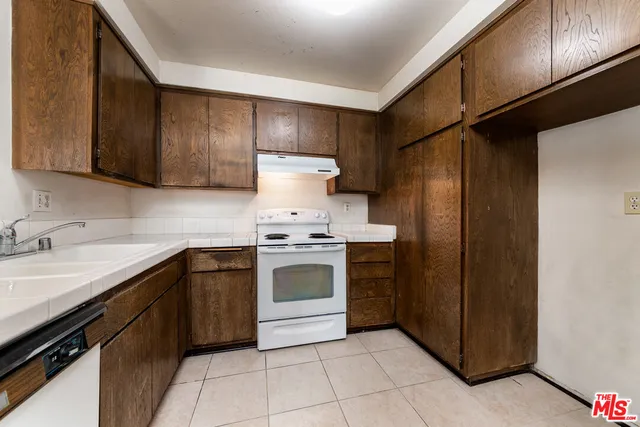 a kitchen with a stove sink and cabinets