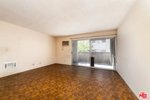 an empty room with sliding door and wooden door