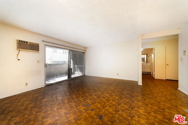 an empty room with mirror and windows