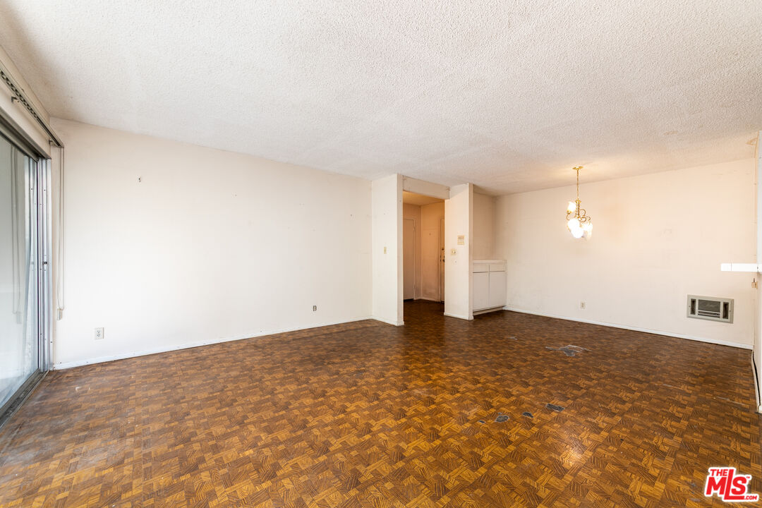 355 South Los Robles Avenue, Unit 108 Pasadena, CA 91101 - Photo 7 of 28 a view of an empty room with wooden floor and a window