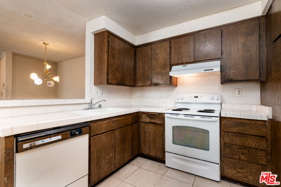355 South Los Robles Avenue, Unit 108 Pasadena, CA 91101 - Photo 10 of 28 a kitchen with a stove sink and cabinets