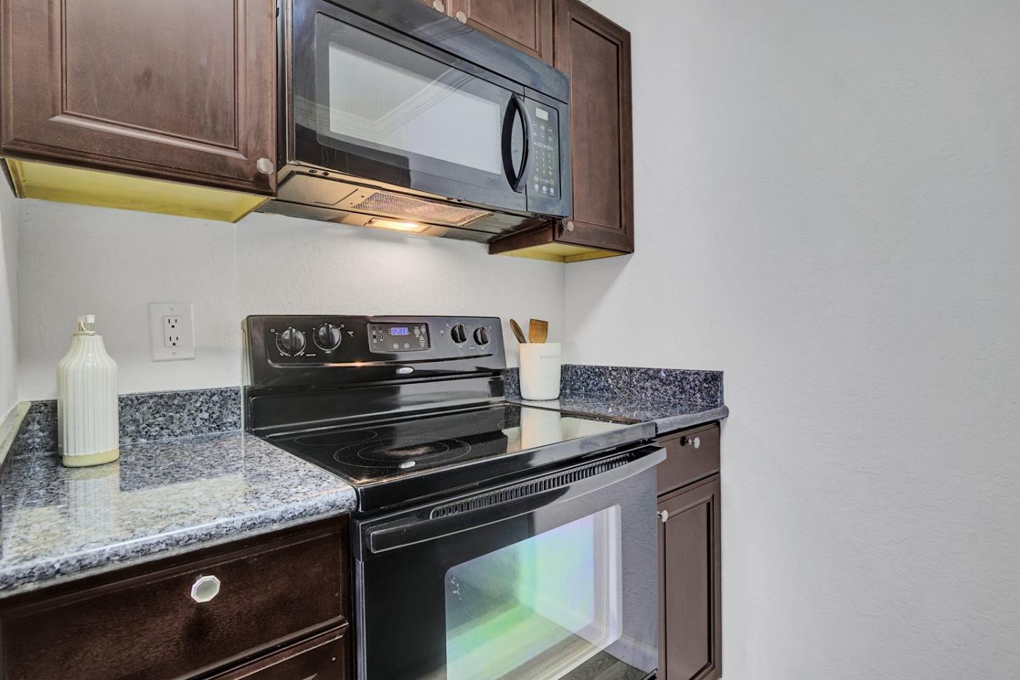 2742 Oak Road, Unit 191 Walnut Creek, CA 94597 - Photo 11 of 36 a kitchen with stainless steel appliances granite countertop a stove and a microwave