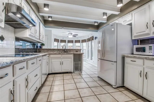 a kitchen with white cabinets appliances and white appliances