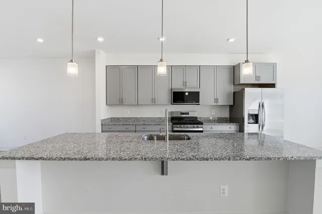 a kitchen with stainless steel appliances granite countertop a sink a stove and a microwave