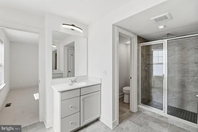 a bathroom with a shower sink and mirror